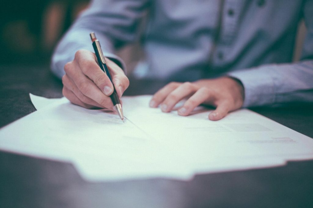 man signing business papers